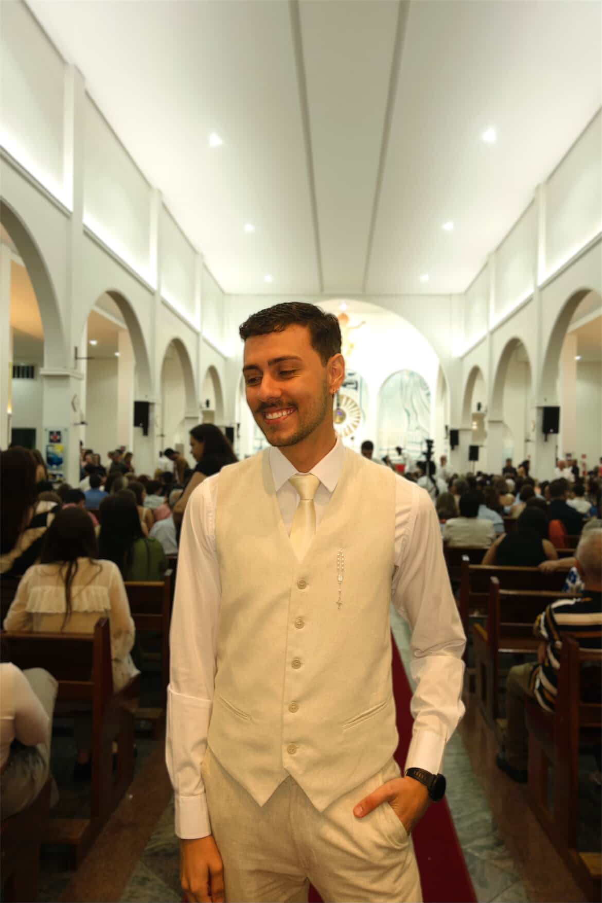 Formando com colete branco durante cerimônia na igreja