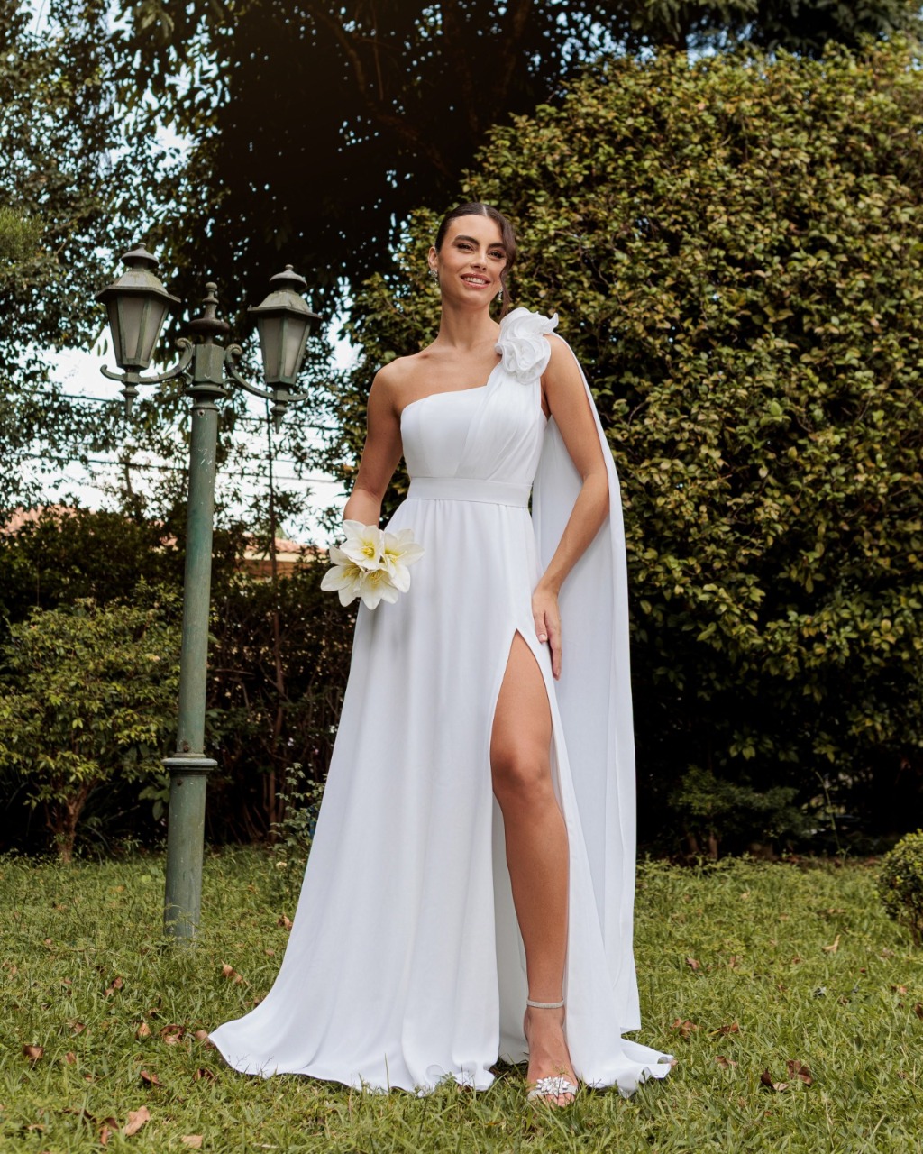 Noiva com vestido de um ombro no jardim